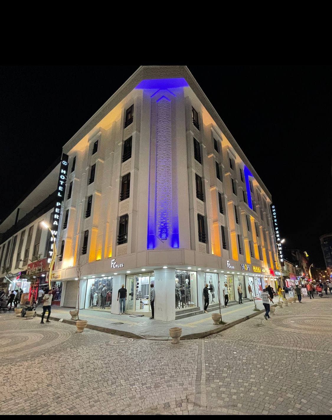 Pera White Hotel'in mavi ve sarı ışıklarla aydınlatılmış gece cephesi