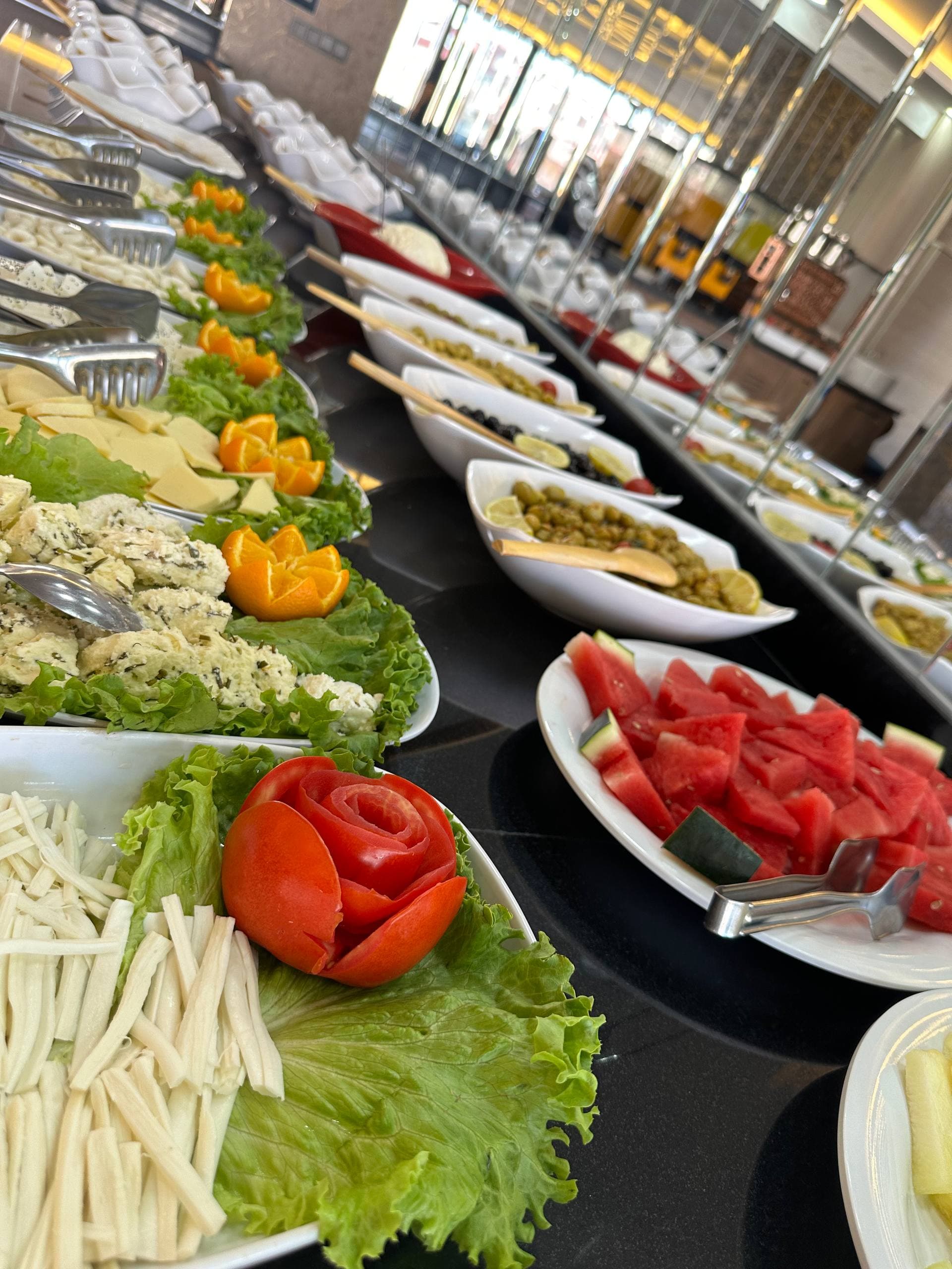 Kahvaltı büfesinde Van peynirleri ve taze yeşilliklerin uzun bir sırası