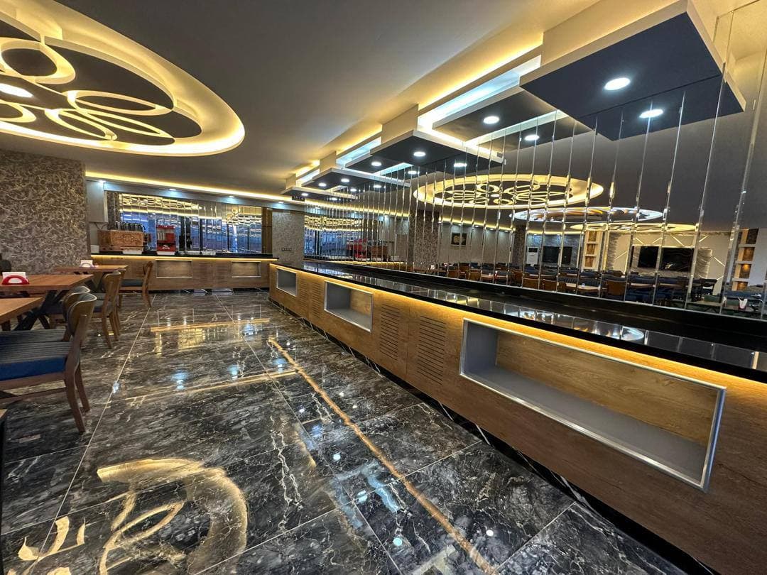 Mermer zeminli açık büfe tezgâhı; sıcak yemekler ve kahvaltı seçenekleri