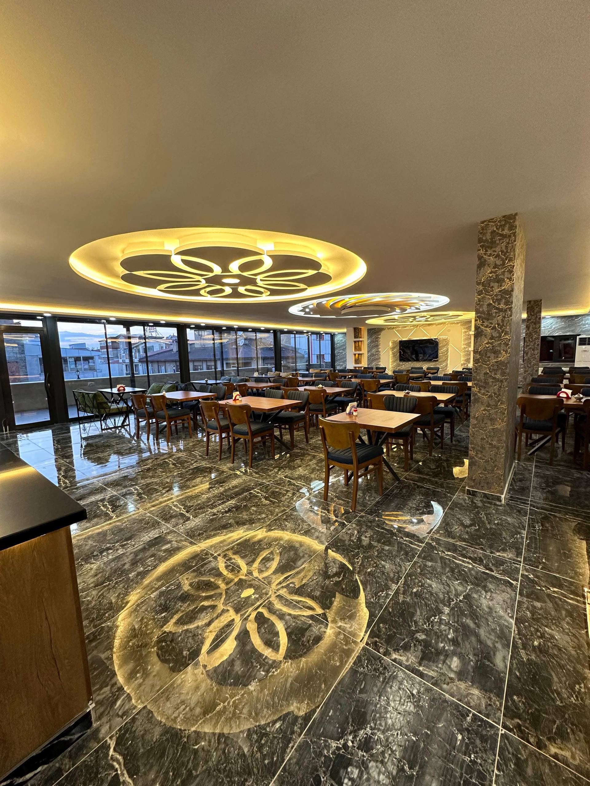 Süslü tavan armatürleri ve cam cepheli pencerelerle uzanan asıl yemek salonu