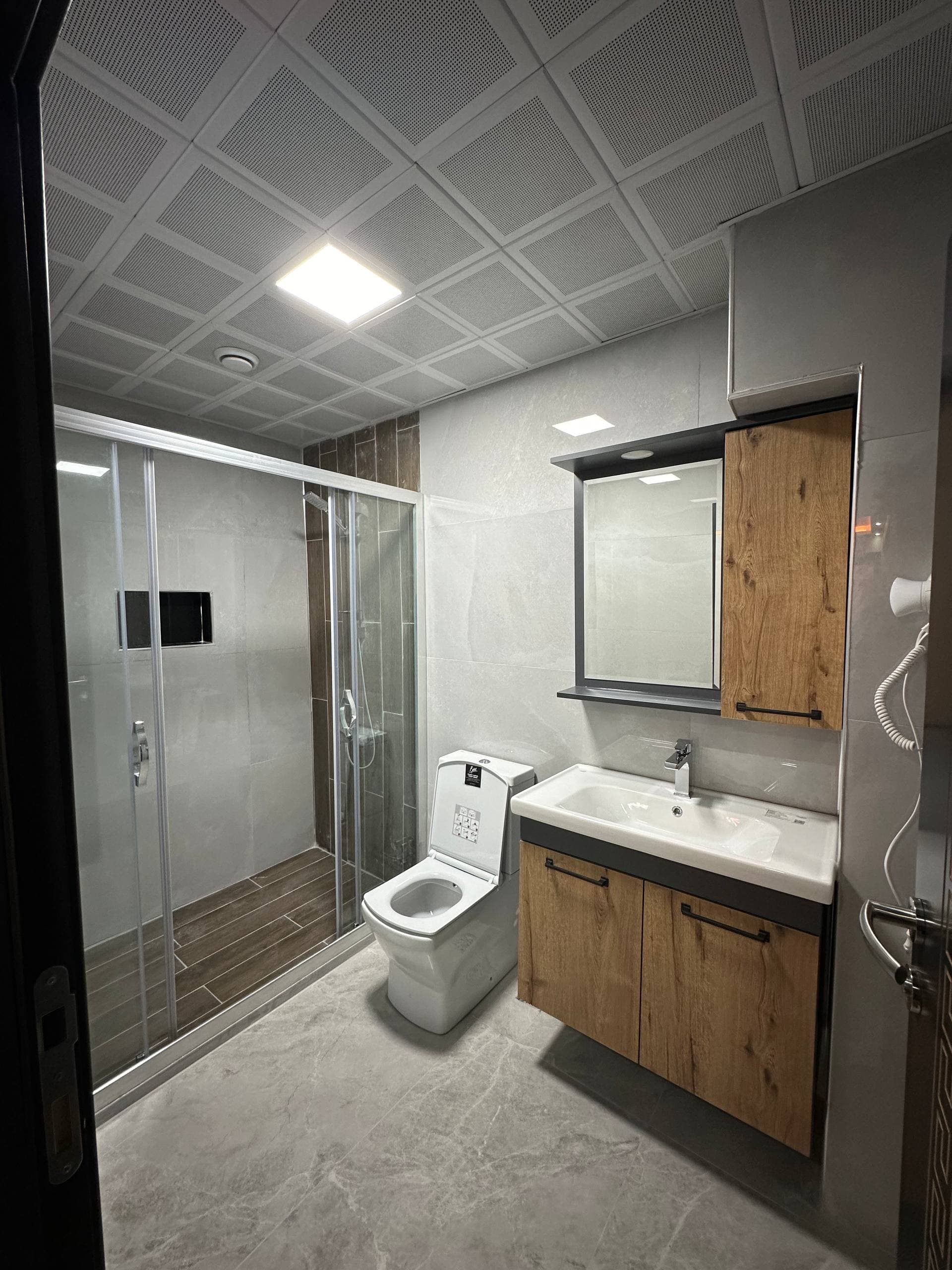 Pencere yanında çalışma masası ve oturma alanı bulunan ferah bir oda