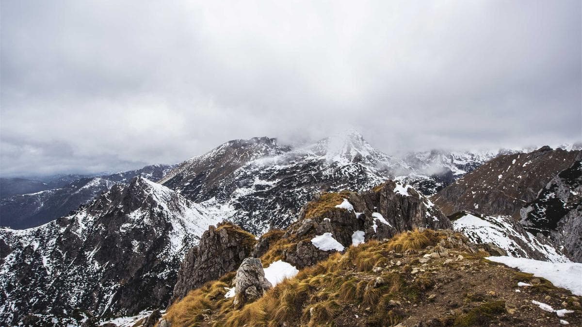 Kış ışığında uzun pencerelerinden göl manzarası görülen sessiz bir otel iç mekânı.